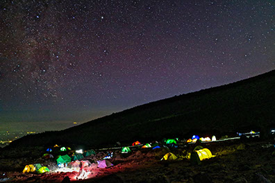 a breathtaking image of night campers gazzing at the night sky