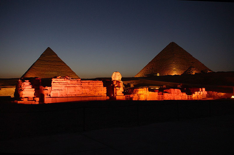 a stunning image of the great pyramids of giza and the sphinx at night